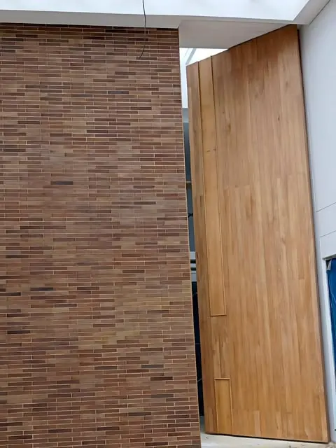 Puerta en madera junto a muro de ladrillo